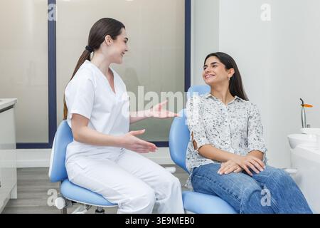 Ein Zahnarzt spricht mit einem Patienten in einer Zahnarztpraxis. Die Diskussion konzentriert sich auf Mundgesundheit und Behandlungsmöglichkeiten. Stockfoto