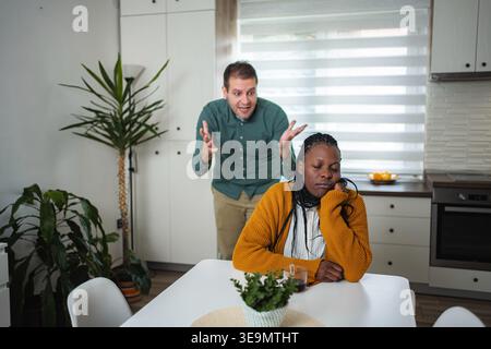 Interrassisches Paar, das ernsthafte Auseinandersetzungen in der Küche hat Stockfoto