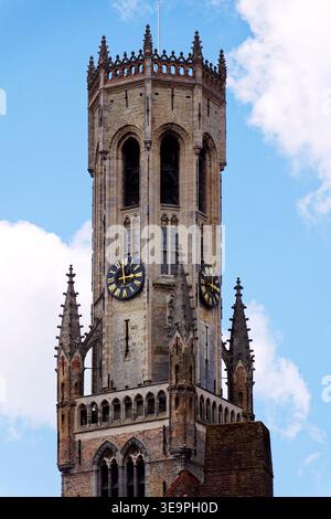 Sonniger Blick auf den Glockenturm von Brügge, der sich über dem historischen Marktplatz erhebt und mittelalterliche flämische Architektur unter einem klaren blauen Himmel zeigt, Brügge, We Stockfoto