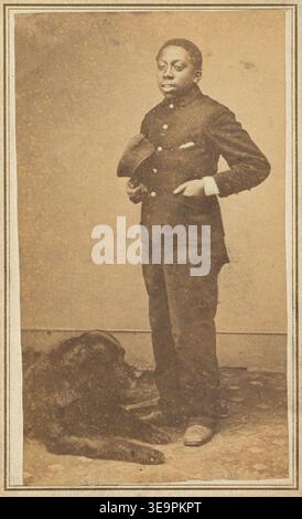 Historisches Porträt eines afroamerikanischen Jungen, der neben einem großen Hund steht, fotografiert in einem Studio, um die 1860er Jahre Stockfoto