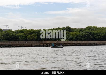 Ein friedlicher Moment in Cienaga de Mallorquin in Barranquilla, Kolumbien, mit zwei Fischern, die ihr kleines Holzboot steuern. Stockfoto