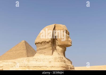 Die große Sphinx von Gizeh in der Nähe von Kairo, Ägypten, steht neben einer Pyramide in der Wüste, einem ikonischen alten Kalksteindenkmal, das an Geschichte, Archäologie und vieles mehr erinnert Stockfoto