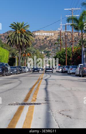 Los Angeles, Kalifornien, USA - 20. Oktober 2024: Blick auf das Hollywood-Schild von der Wohnstraße mit Palmen und Autos Stockfoto