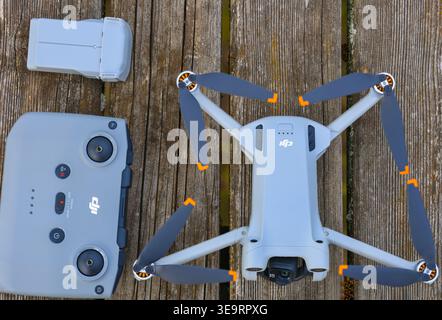 Dijon, Frankreich - 1. April 2026: Ein professionelles DJI-Drohnenset wird auf einem groben Holzgartentisch angeordnet. Das Set enthält das Flugzeug, die Fernbedienung Stockfoto