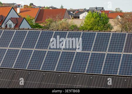 Solarpaneele, die auf Dächern in einem Wohnviertel installiert sind und Technologien für erneuerbare Energien, nachhaltiges Wohnen und moderne umweltfreundliche Technologien erfassen Stockfoto