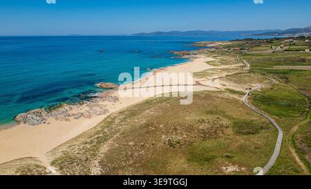 Diese Luftaufnahme fängt die unberührte Schönheit von Praia de Espiñeirido in Galicien ein. Der lange Abschnitt des feinen Sandes wird von einer hölzernen Promenade begrenzt Stockfoto
