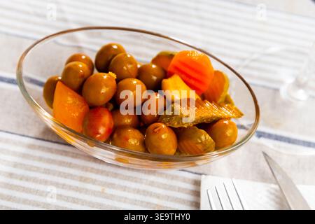 Grüne Oliven serviert mit Gurke, Karotte, Knoblauch und Zwiebeln Stockfoto