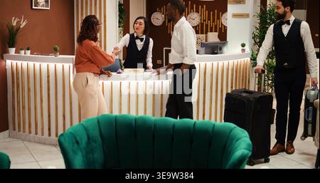 Touristen, die während der Buchung im Luxushotel während der Urlaubsreise mit Kreditkarte bezahlen. Paare, die in den Flitterwochen Urlaub buchen, Upgrade nicht im Preis inbegriffen Stockfoto