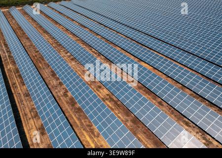 Drohnenansicht von Reihen von Solarpaneelen, die auf dem Boden installiert sind und erneuerbare Energie in einem modernen Solarpark erzeugen, der eine saubere, nachhaltige Stromerzeugung ermöglicht Stockfoto