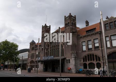 Jugendstil-Backsteinfassade des Bahnhofs Haarlem mit dramatischen Sturmwolken. Haarlem, Niederlande. Stockfoto