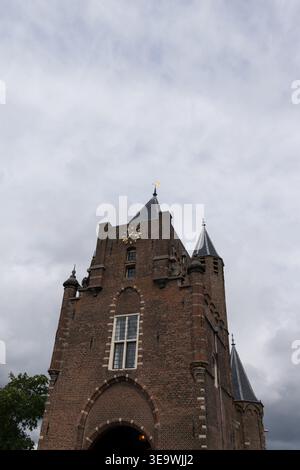 Amsterdamse Poort, ein mittelalterlicher Stadttor in Haarlem, Niederlande, fotografiert aus niedrigem Winkel vor bewölktem Himmel. Stockfoto