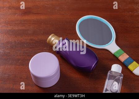Studio-Aufnahme mit einem Arrangement von Kosmetikprodukten. Draufsicht, minimalistische Einrichtung. Textur der Holzoberfläche. Durch sanftes Licht beleuchtet, Fokus auf ca. Stockfoto