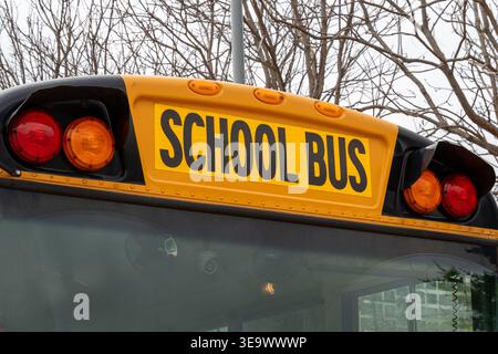 Nahaufnahme des legendären „SCHOOL BUS“-Schriftbildes auf einem amerikanischen gelben Schulbus mit auffälligen horizontalen Schildern Stockfoto