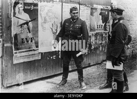 Jacques Doriot (1898–1945) war ein rechtsextremer französischer Politiker und Gründer der Französischen Volkspartei (PPF). In der Zeit von 1940 bis 1944 arbeitete er mit Nazi-Deutschland zusammen und wurde oft in deutscher Uniform gesehen. Dieses Archivbild zeigt ihn vor den Plakaten der Legion französischer Freiwilliger gegen den Bolschewismus. Stockfoto