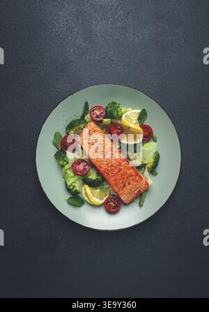 Gegrilltes Lachsfilet mit Gemüse, Brokkoli, Kirsche, Eisbergsalat, Gewürze und Kräuter, hausgemacht, keine Leute Stockfoto