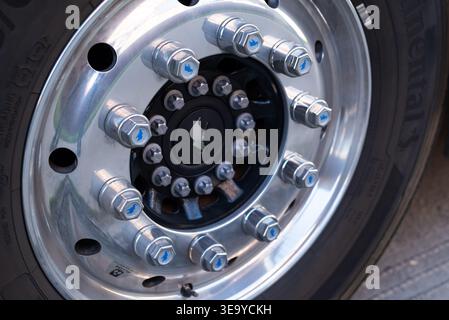 Riesiger Autoreifen mit großem Reifenprofil und Schmitz-Mutternkappe Chrom-Nahaufnahme Stockfoto