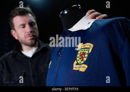 AM DIENSTAG, 21. APRIL 0001 GESPERRT, sieht sich Ein Mitarbeiter von Propstore Steve Nicol sein Match-getragenes Scotland gegen England 1988 Rous Cup-Trikot (EST 1.000–2.000 £) während einer Vorschau auf den bevorstehenden Steve Nicol-Erinnerungsverkauf im Propstore in Rickmansworth, Hertfordshire an. Bilddatum: Dienstag, 14. April 2026. Stockfoto