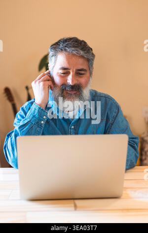 Reifer Mann, der im Heimbüro Remote am Laptop arbeitet Stockfoto
