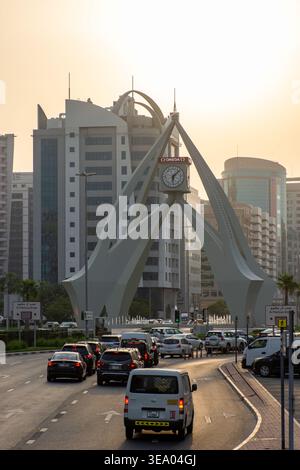 Erhöhter Blick auf den starken Verkehr, der sich dem berühmten Deira Clocktower Monument bei Sonnenuntergang in Dubai, Vereinigte Arabische Emirate nähert. Stockfoto