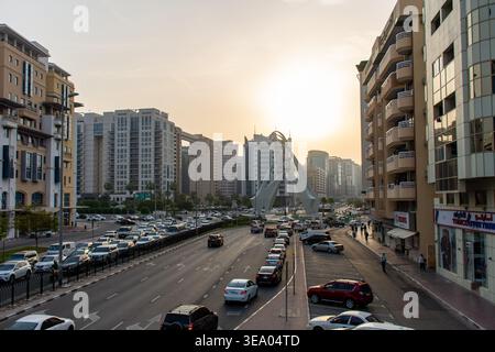 Erhöhter Blick auf den starken Verkehr, der sich dem berühmten Deira Clocktower Monument bei Sonnenuntergang in Dubai, Vereinigte Arabische Emirate nähert. Stockfoto
