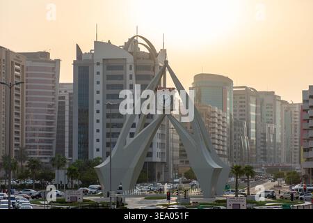 Erhöhter Blick auf den starken Verkehr, der sich dem berühmten Deira Clocktower Monument bei Sonnenuntergang in Dubai, Vereinigte Arabische Emirate nähert. Stockfoto