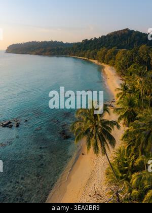 Erleben Sie die Ruhe des Takhian Beach auf Koh Kood, Thailand, während die Sonne über dem ruhigen Wasser untergeht und eine malerische Szene schafft. Stockfoto
