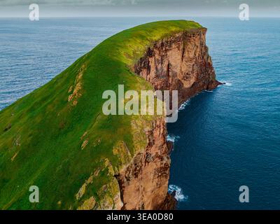 Blick aus der Vogelperspektive auf die zerklüftete Küste, wo smaragdgrüne Klippen auf das tiefblaue Meer bei Ilhéus das Cabras, Terceira, Azoren, Portugal treffen. Stockfoto