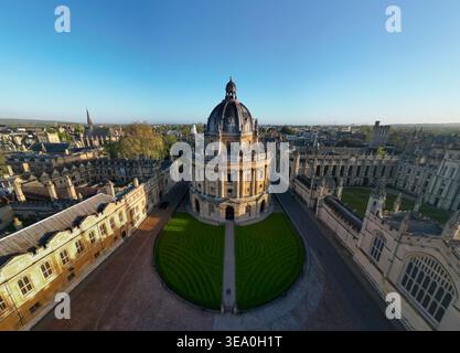 Weite Drohnenansicht der Radcliffe Camera, umgeben von College-Quads und Oxford Skyline im goldenen Morgenlicht, Oxfordshire Stockfoto