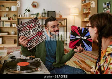 Ein Erwachsener vergleicht Vinyl-Schallplatten während des Hörens von Home Music Stockfoto