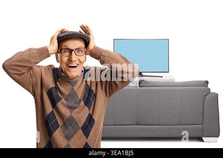 Ein aufgeregter älterer Mann, der seinen Kopf vor einem fernsehbildschirm auf weißem Hintergrund hält Stockfoto