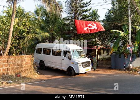 Kommunistische Symbole auf den Straßen Kannur Stadt in Kerala in Indien, Hammer und Sichel auf einer roten Flagge, Fahnen hängen über den Straßen, öffentliche Busse Stockfoto