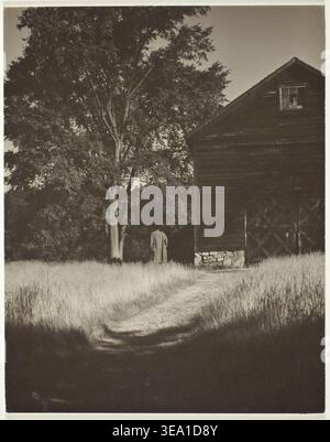 Scheune, Lake George von Alfred Stieglitz, 1936, einsame Figur, die vor verwittertem Holzbau steht, umgeben von bewachsenem Gras und Bäumen Stockfoto