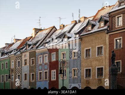 Alte Häuser auf dem Marktplatz in Posen. Reihe farbenfroher traditioneller Häuser auf dem Alten Marktplatz von Posen mit verzierten Fassaden und schneebedeckten Dächern. Stockfoto