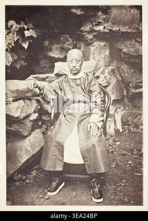 Prinz Kung von John Thomson, um 1868, ein chinesischer kaiserlicher Beamter, der in besinnlicher Pose neben felsiger Landschaft mit Laub sitzt Stockfoto