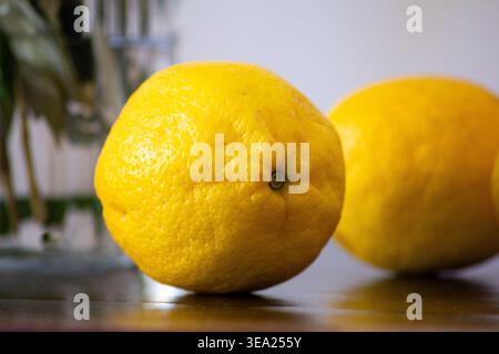 Frische gelbe Zitronen auf der Küchentheke mit geringer Schärfentiefe - Nahaufnahme Stillleben von Zitrusfrüchten Stockfoto