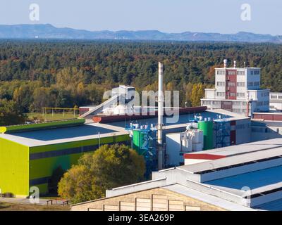 Diese Luftaufnahme zeigt eine große Aluminiumfabrik mit Metallproduktionsanlagen und Infrastruktur in ländlicher Umgebung. Stockfoto