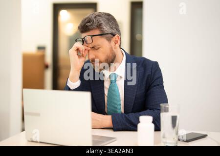 Müder Mann fühlt Schmerzen, wenn er die Brille festhält, trockene gereizte Augen ermüdet von der Computerarbeit, gestresster Mann leidet an Kopfschmerzen, Sehstörungen Stockfoto