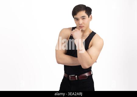 Junger Mann in schwarzem Tank Top posiert mit Händen auf dem Kopf Stockfoto