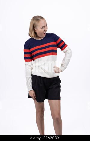 Junger Mann in gestreiftem Pullover, der steht und wegblickt Stockfoto