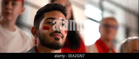 Begeisterte Fußballfans, die die Nationalmannschaft von Monaco bei einem Live-Fußballspiel im Stadion unterstützen. Stockfoto