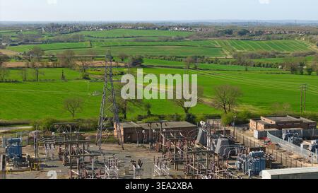 Aus der Vogelperspektive der Coalville Umspannstation mit elektrischen Pylonen und Transformatoren mit Blick auf üppige grüne Felder und ländliche Landschaften in Coalville, Engla Stockfoto