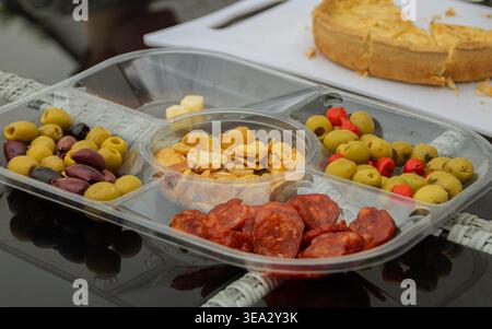 Eine Auswahl an Tapas mit Oliven, Chorizo und Bohnen in einem Tablett im Freien. Stockfoto
