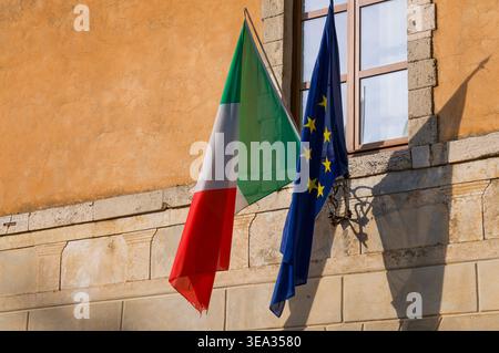 Nahaufnahme der italienischen und europäischen Flagge, die vor einem Verwaltungsgebäude in Pienza, Italien, hängt Stockfoto