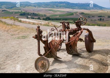 Der alte Rusty-Maschinenpflug wurde auf einem landwirtschaftlichen Feld in der Toskana, Italien, verlassen Stockfoto