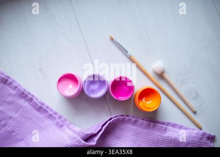 Farben in Gläsern, Acrylfarbe und Pinsel auf weißem Hintergrund Stockfoto