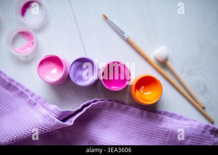 Farben in Gläsern, Acrylfarbe und Pinsel auf weißem Hintergrund Stockfoto