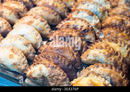 Köstliche Empanadas, die sich in Reihen im Schaufenster aufreihen Stockfoto