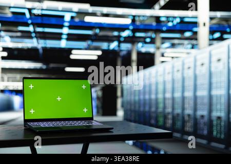 Laptop mit isoliertem Bildschirm im Rechenzentrum zur Auswertung von Diagnoseberichten für Geräte-Mainframes. Chroma Key-Notebook in der Serverfarm zur Automatisierung der Verarbeitung von Supercomputern, Nahaufnahme Stockfoto