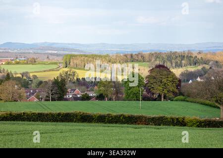 Malerischer Blick auf das Dorf Cleobury Mortimer, eingebettet in die Landschaft von Shropshire, mit dem historischen Kirchturm und sanften grünen Ackerland Stockfoto