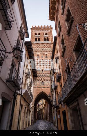 Eine perspektivische Sicht auf den San Salvador Turm in Teruel, Spanien. Dieser majestätische Glockenturm aus dem 14. Jahrhundert im aragonesischen Mudéjar-Stil ragt über einem schmalen Turm Stockfoto
